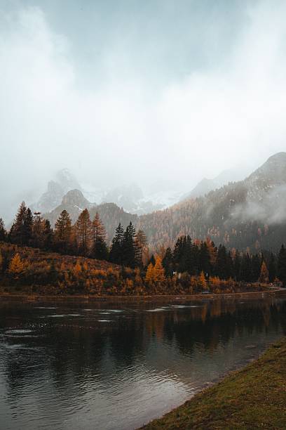 istock Misty autumn landscape with a calm reflective lake. 2245109351