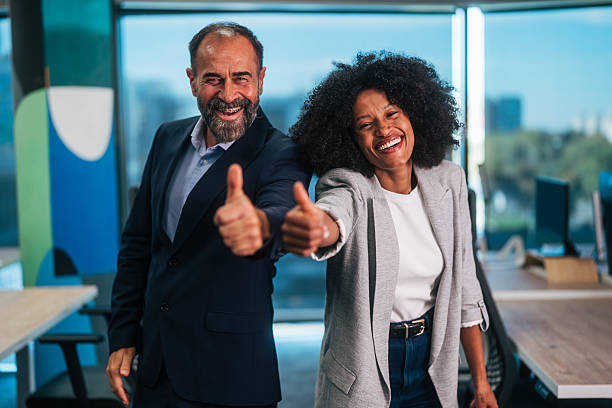 istock Business colleagues giving thumbs up in office 2245109737