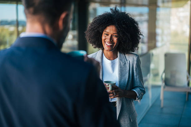istock Businesswoman smiling while networking with colleague during coffee break 2245110164
