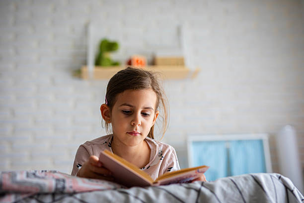 istock Child Relaxing in Bed with a Book 2245110995