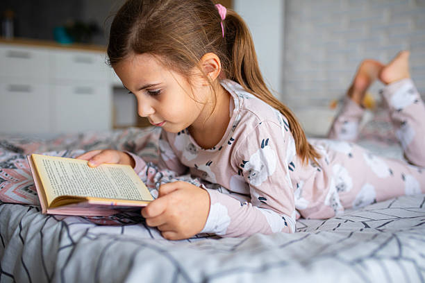 istock Child Relaxing in Bed with a Book 2245111757