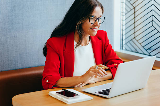 istock Professional woman in a red blazer working on a laptop computer 2245114906