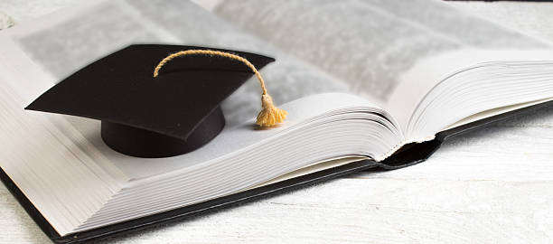 istock Open book on wooden deck table and black board background. Back to School. Education concept with copy space for your ad text. 2245115424
