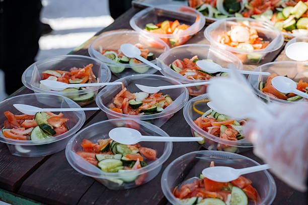 There is a delightful table topped with an assortment of colorful plastic bowls, each filled with a variety of fresh vegetables, accompanied by spoons for serving and enjoying the meal