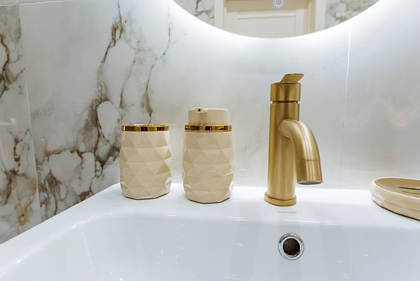 istock A bathroom sink with a gold faucet and a mirror 2245115841