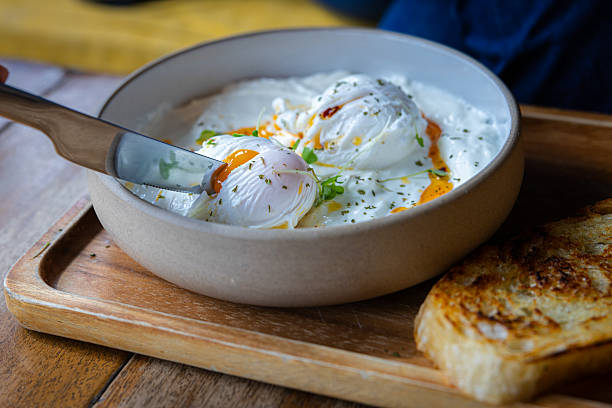 Poached egg serving with garlic yogurt, breakfast plate.
