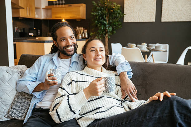 istock Heterosexual multiethnic couple at home enjoying evening and drinking coffee or tea while enjoying the view 2245119242