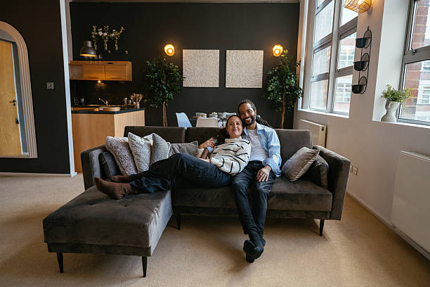 istock Multiethnic couple enjoying the time at home, sitting on comfortable couch 2245119277
