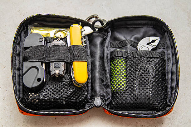istock Open orange EDC pouch with multitool, flashlight, lighter, and other survival gear. Everyday carry organizer 2245120898