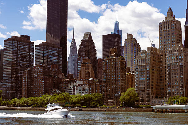 A dynamic cityscape with high-rise buildings and a boat cruising in the river. Perfect for urban and travel themes.