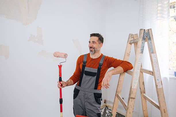 istock Happy Man in Overalls with Paint Roller 2245121646