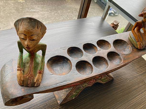 Traditional Indonesian wooden congkak board with wayang carving