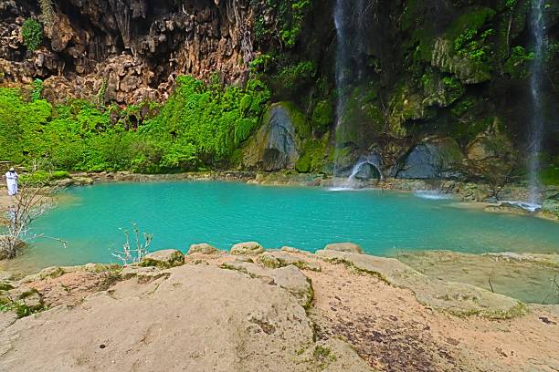 istock Tranquil turquoise pool with waterfalls and greenery. 2245121896