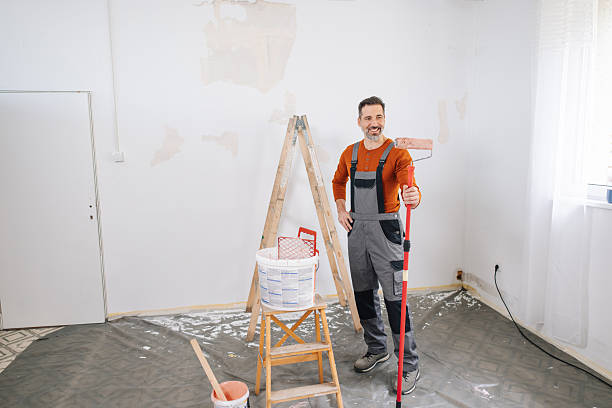 istock Man Painting Wall with Roller in Stylish Room 2245122106