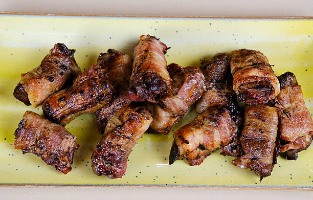 istock Bacon wrapped chicken drumsticks in a black cast-iron skillet on the stone background. 2245123256