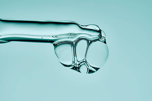 istock The texture of a serum with bubbles dripping from a pipette on a mint background. 2245125791