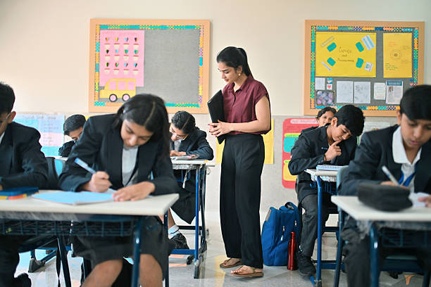professor supervisionando alunos do ensino médio durante os exames de classe - sala de prova - fotografias e filmes do acervo