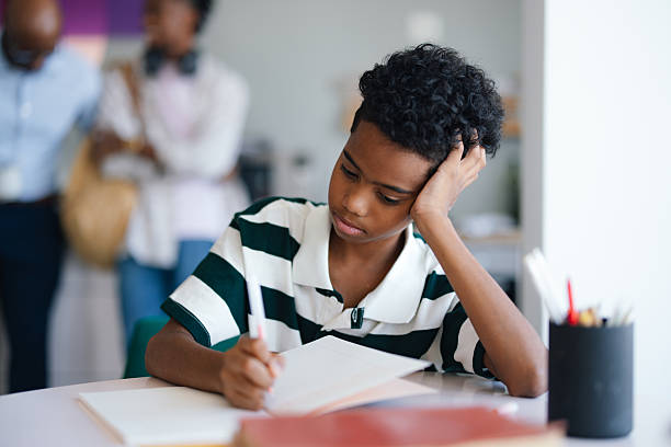 istock Young Student Focused on Homework at Desk in Cozy Apartment Kitchen Setting 2245126466