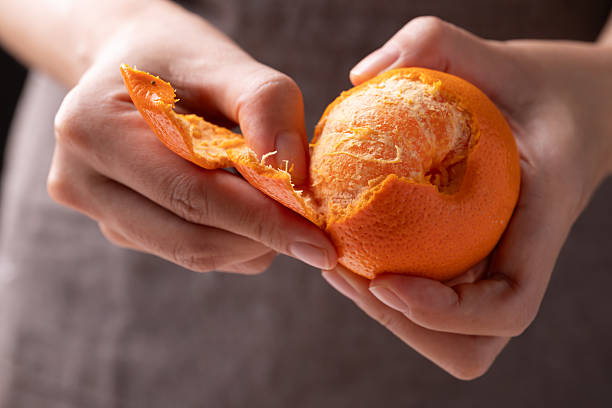 Mandarin orange fruit peeling by hand and eating