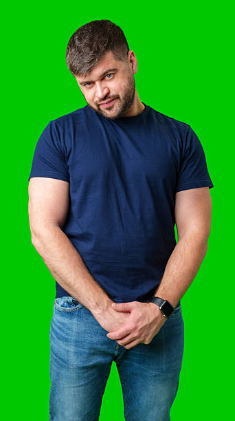 istock Man standing with a thoughtful expression in a casual outfit against a green background 2245127937