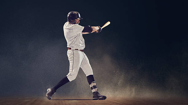 istock Baseball batter mid-swing making contact with ball on field under dramatic light 2245130166
