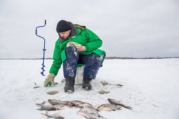 istock a man catches fish in winter 2245133387