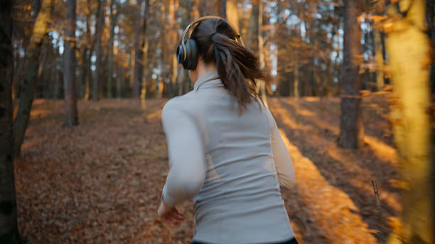 istock Young Caucasian Female Running Through Vibrant Autumn Forest 2245134807