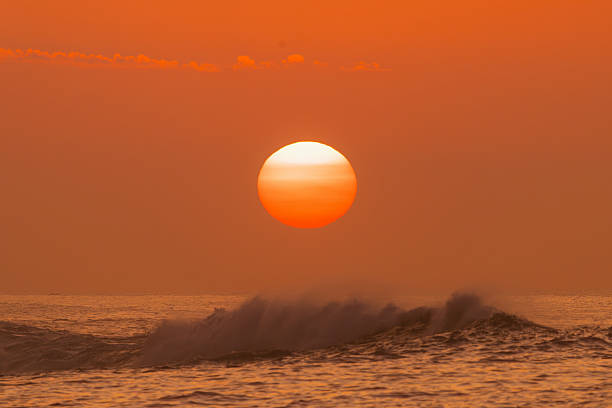 Ocean waves crashing with sunrise glow on horizon, golden sky and water spray — seascape, coastal sunrise, nature, ocean energy, scenic beauty concept.
