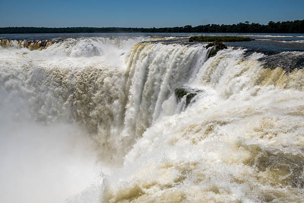 Iguacu Falls in Brazil in the foreground and Argentina seen beyond the river