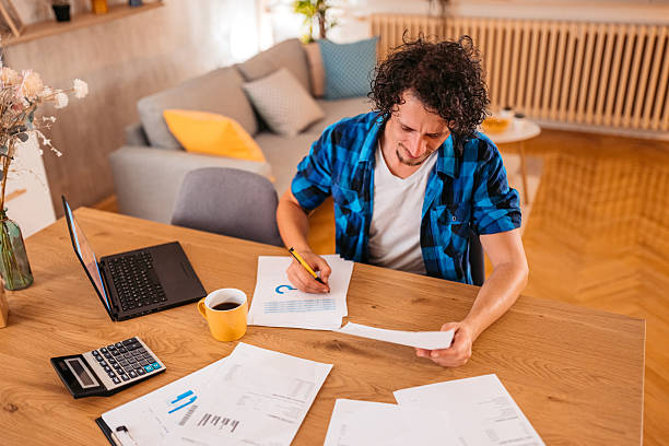 istock Mid-Adult Man Checking His Finances At The Kitchen Table At Home 2245138672