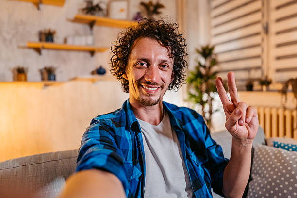 istock Mid-Adult Man Taking Selfies On The Sofa At Home 2245138968