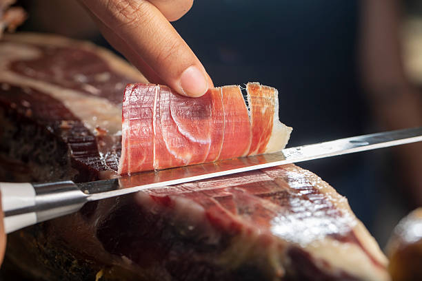 istock Slicing Iberian ham close up with knife 2245140782