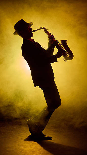 istock Jazz saxophonist performing on stage with artistic smoke lighting 2245141027