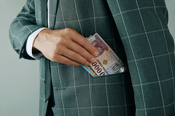 istock man putting Hungarian forints in pocket 2245142914