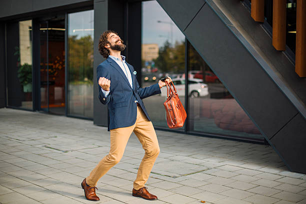 istock Happy businessman celebrating success outdoors holding briefcase 2245143723