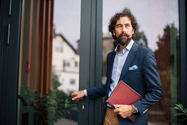 istock Businessman opening office door leaving building with document 2245144279