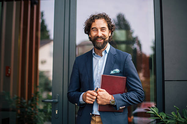 istock Confident businessman standing outside modern office building 2245144524
