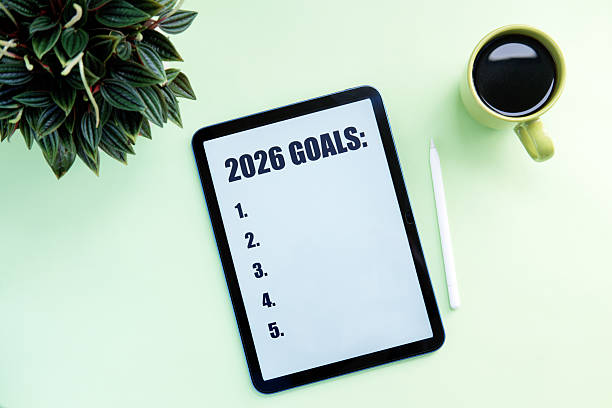 istock 2026 GOAL with digital tablet, coffee cup and pen on light green background. 2245144774