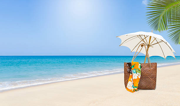 Tropical beach background, summer outdoor day light, beach bag and white umbrella on summer beach