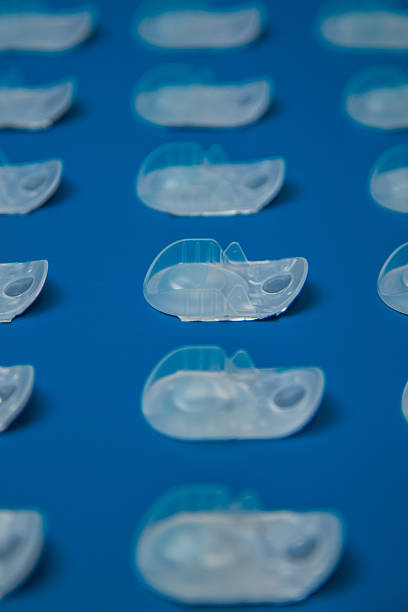 istock Side view pattern of disposable contact lens containers lying in a row at the same distance on a blue background. Concept of vision correction, ophthalmology, myopia and hyperopia 2245148347