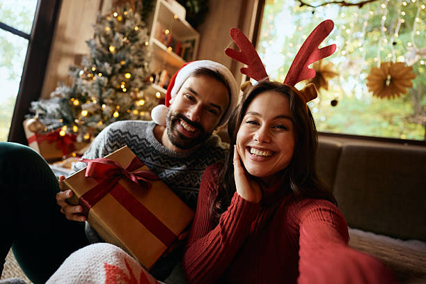 istock Joyful couple taking selfie while celebrating Christmas at home. 2245148532