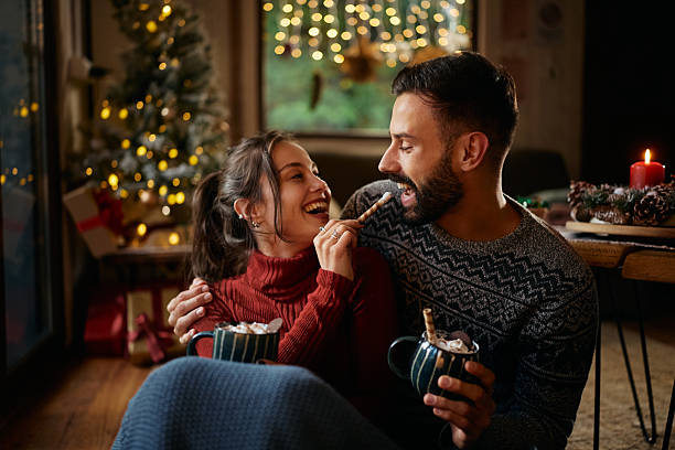 istock Happy couple having fun while drinking hot chocolate on Christmas at home. 2245148812