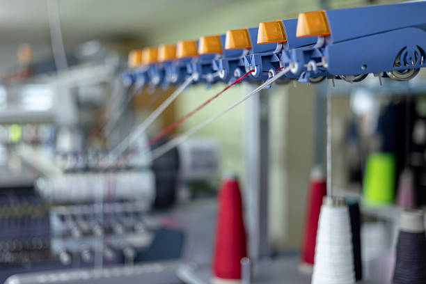 istock A close-up, selective focus view of the thread guide rail on an industrial knitting machine. Red and white yarns are fed through the sensors of the automated equipment in a knitwear factory. 2245150786