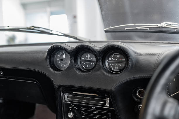 Vilnius, Lithuania - April 11, 2023: Original gauges in the dashboard of a vintage Datsun 240Z. Showing engine temperature, oil temperature and pressure and various other parameters. Dash freshly reupholstered in black leather.