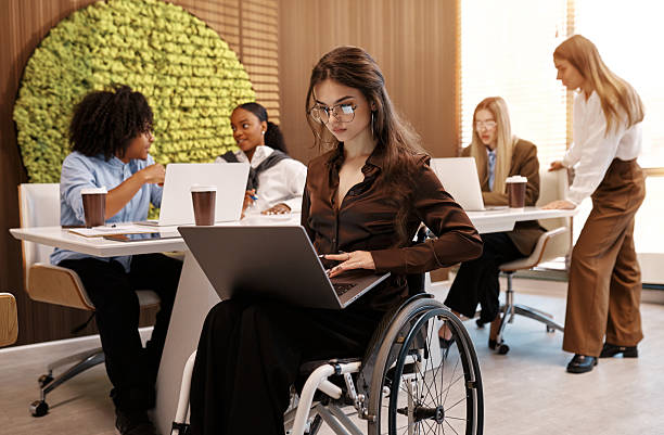 istock Confident woman working on laptop in modern inclusive office, using wheelchair 2245154526
