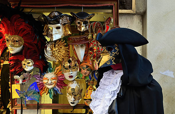 Venice, Italy - Mar 6, 2011: Venice shop showcase, Venetian carnival costumes - symbol of Venice.  Tourists from all the world enjoy historical city of Venezia in Italy, UNESCO World Heritage Site
