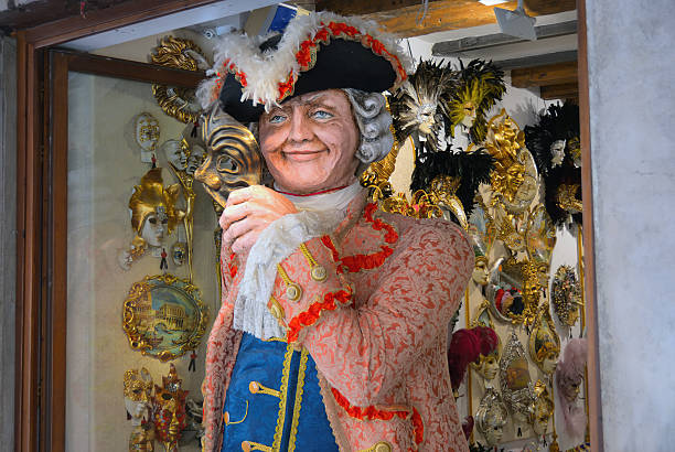 Venice, Italy - Mar 6, 2011: Venice shop showcase, Venetian carnival costumes - symbol of Venice. Tourists from all the world enjoy historical city of Venezia in Italy, UNESCO World Heritage Site