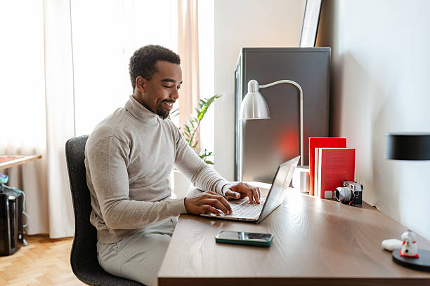 istock Mid-aged African American man using laptop at home office 2245157413