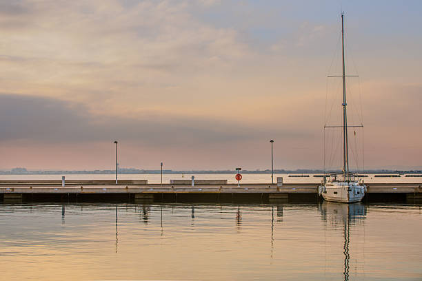Beautiful seascape with sailing boat in the distance and pier.