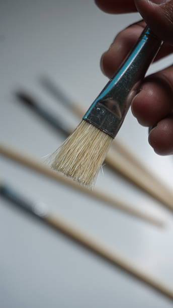istock Paint brush in hand on a white background, close-up 2245158983
